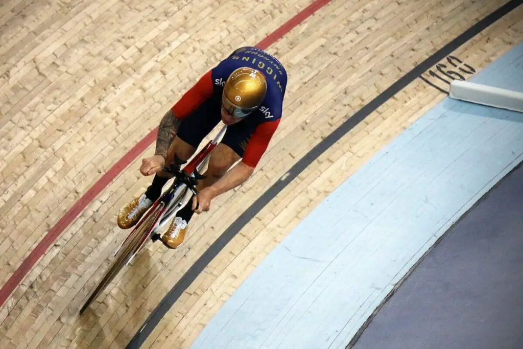 Image of a man on fixie at velodrome riding a brakeless track bike.