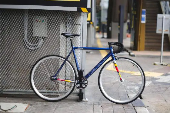 Blue Tsunami SNM100 single speed bike with drop bars on city streets.