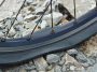 Black flat tire on gravel road. Source: Adobe Stock