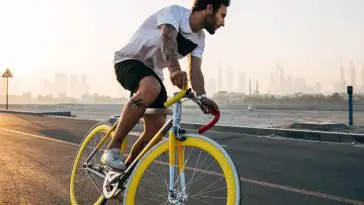 Image of a man riding fixed gear bike with a sunset backdrop.
