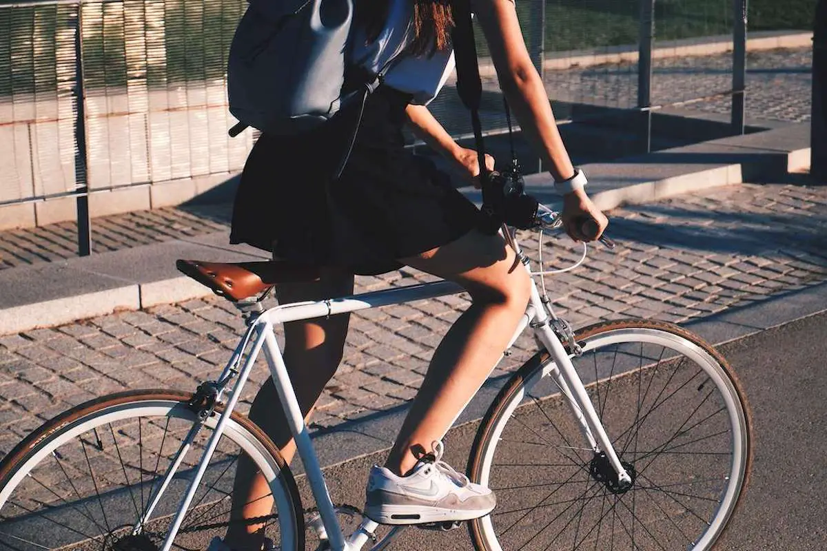 Young woman riding a white single speed bike. Source: Murillo De Paula, Unsplash