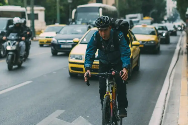 Image of a man commuting to the city with a single speed bicycle. Source: Angelo Pantazis, Unsplash