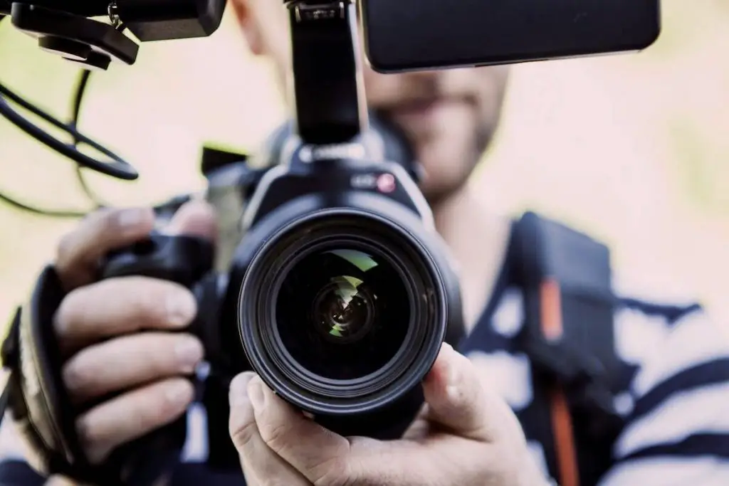 A man holding a camera recording a youtube video. Source: terje sollie , pexels