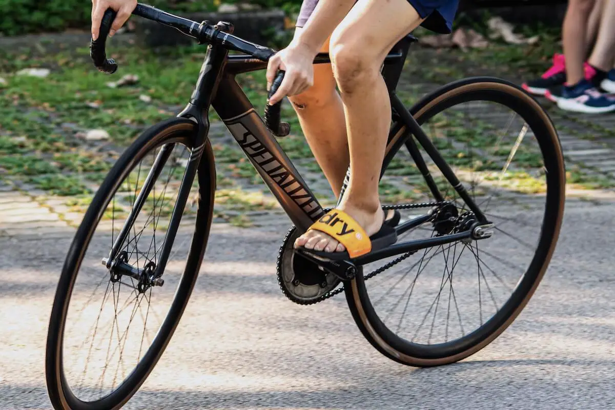 Cyclist wearing flip flops doing a track stand on a specialized fixed gear bike. Source: lukas smith, unsplash