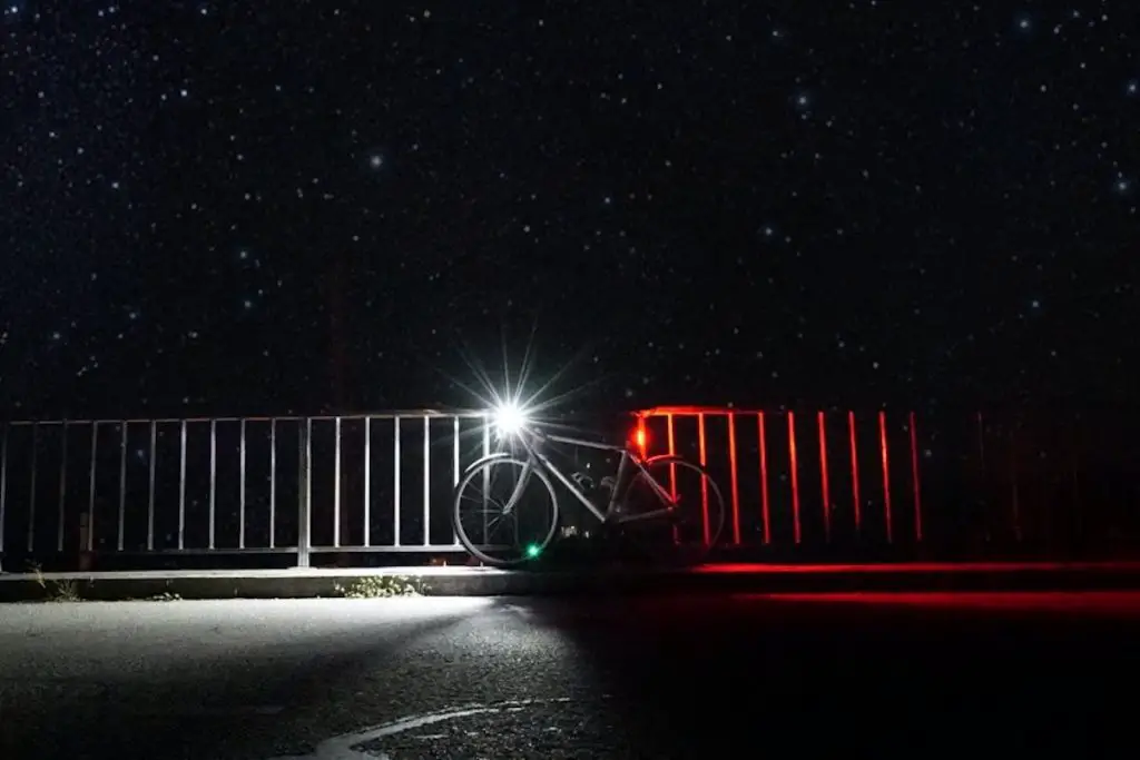 Image of bicycle at night with head and tail lights on flo maderebner pexels