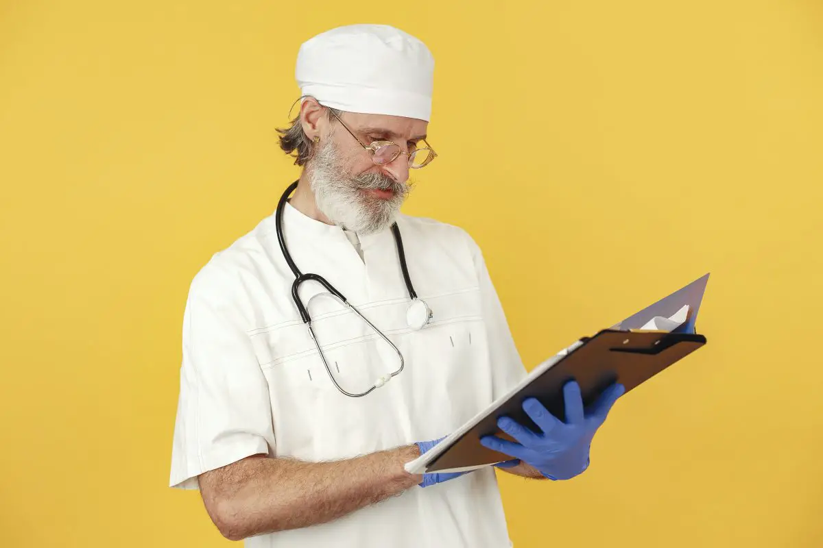 Image of doctor looking at charts on yellow backdrop. Source: gustavo fring, pexels