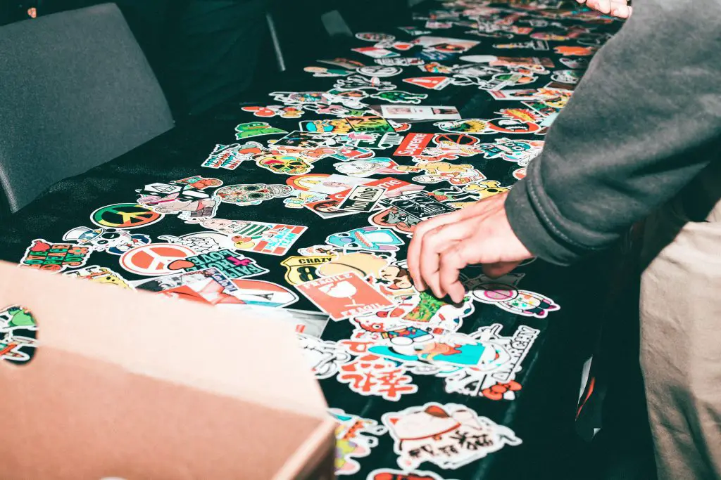 Image of table with a bunch of stickers laid out on it. Source: javon swaby, pexels