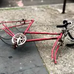 Image of a disassembled and old red bike frame. Source: Lance Grandahl, Unsplash