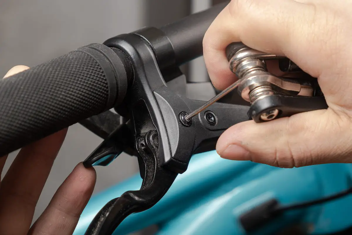 Adjusting the hydraulic brake on the bike with the multitool. Source: adobe stock