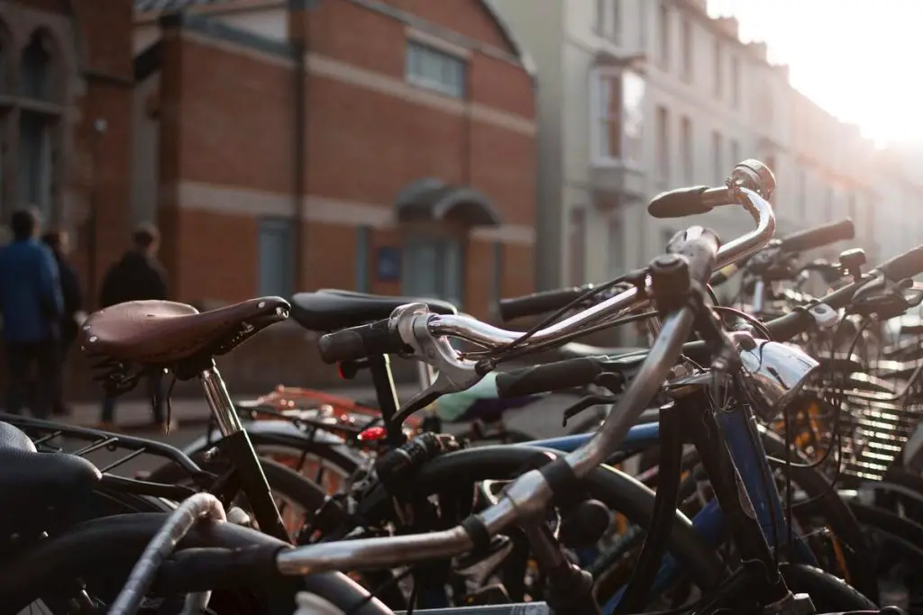 Image of a bicycle with a leather saddle parked outside beside other bikes. Source: unsplash