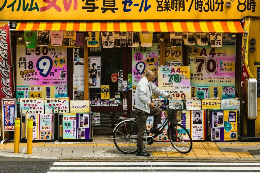 Image of a man on a bicycle in oshiage japan unsplash