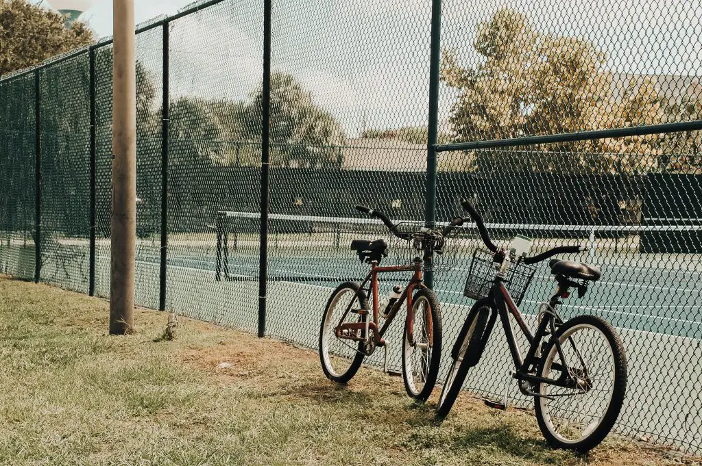 Two bikes left outdoors by a tennis court. Source: burst