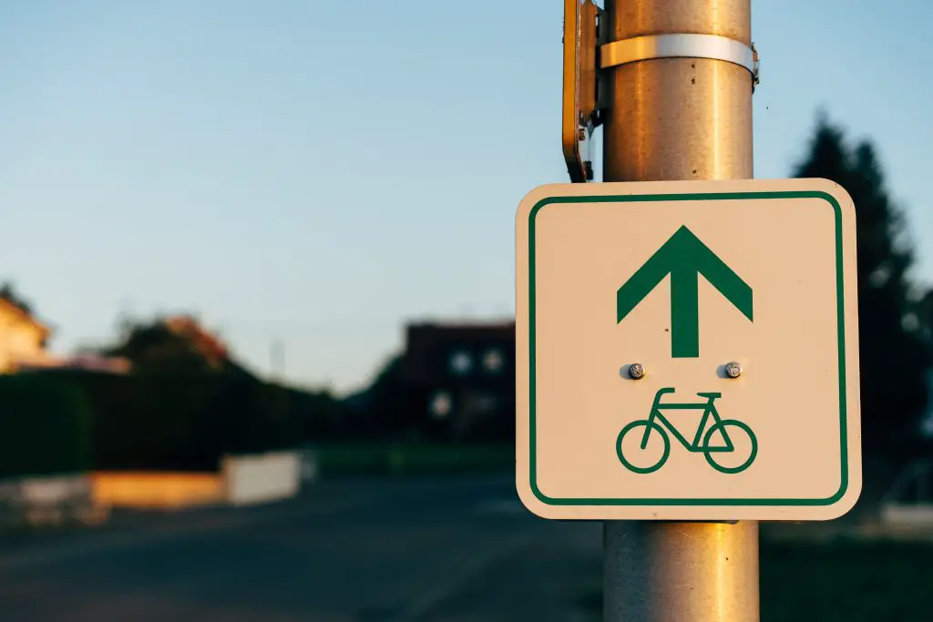 Image of bike lane sign in green. Source: unsplash
