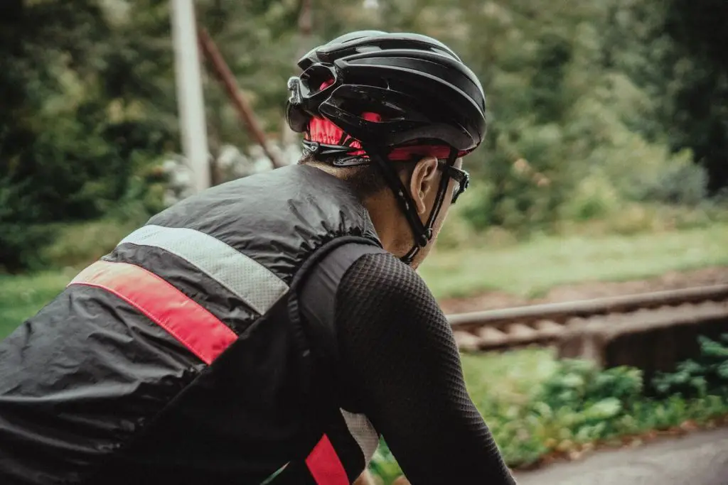 Image of a cyclist wearing a black bike helmet while on the road. Source: unsplash