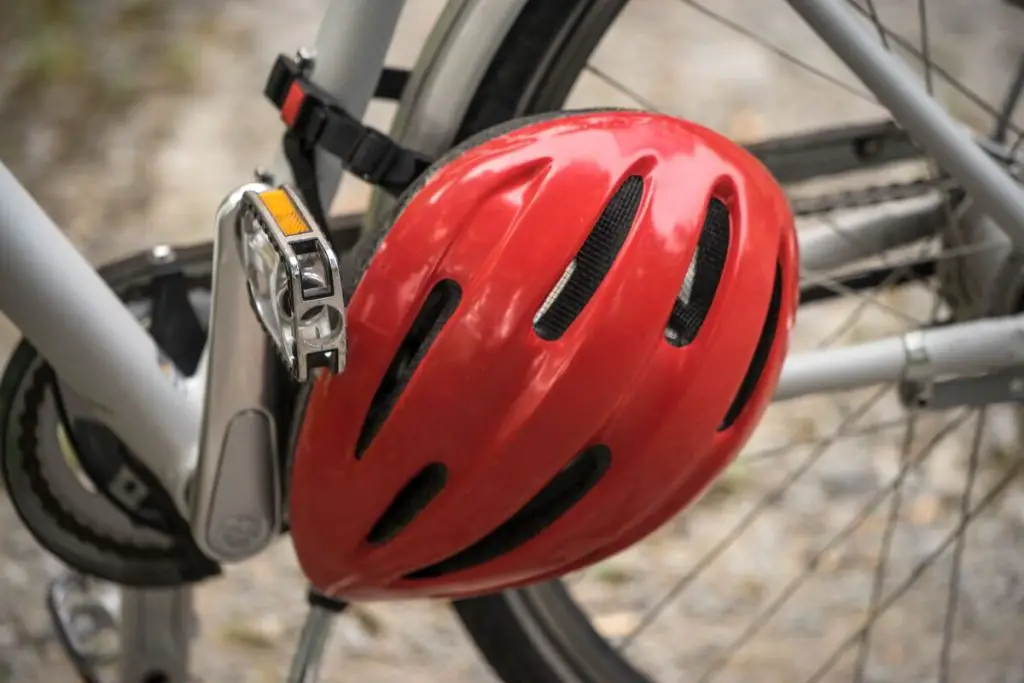Image of a red bike helmet hanging on a bike. Source: Unsplash