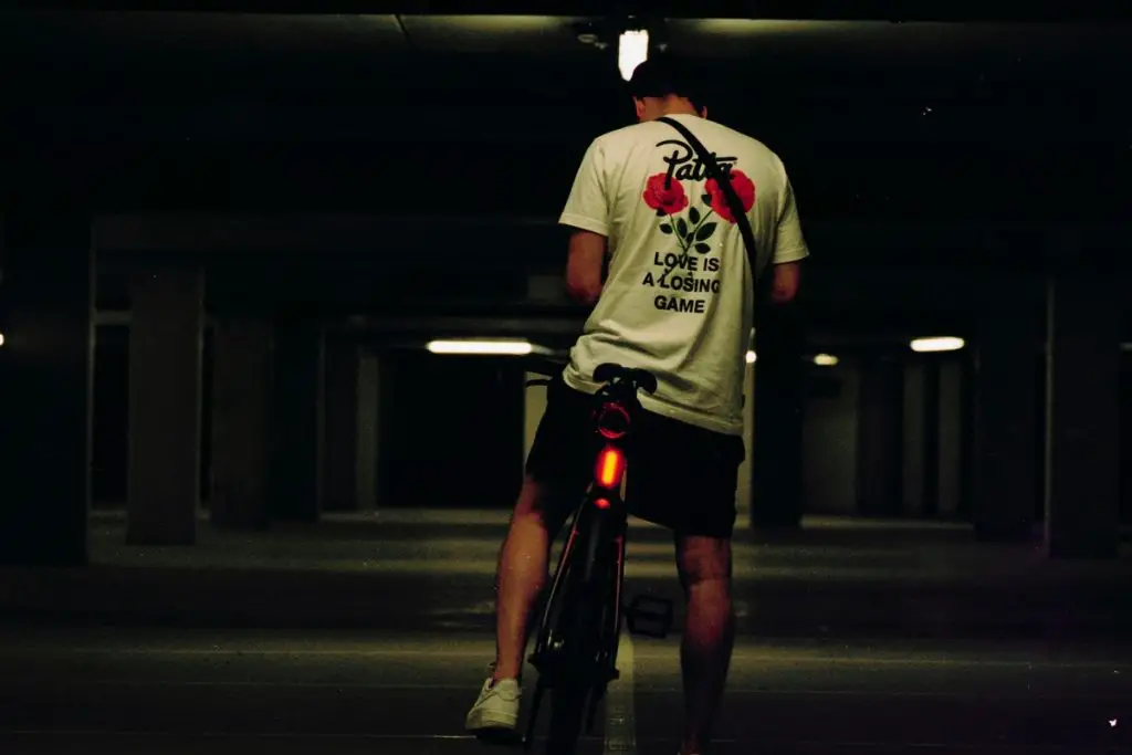 Image of a commuter cyclist with rear lights on during nighttime source unsplash