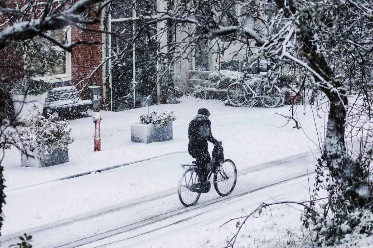 A cyclist on a snowy street. Source: unsplash