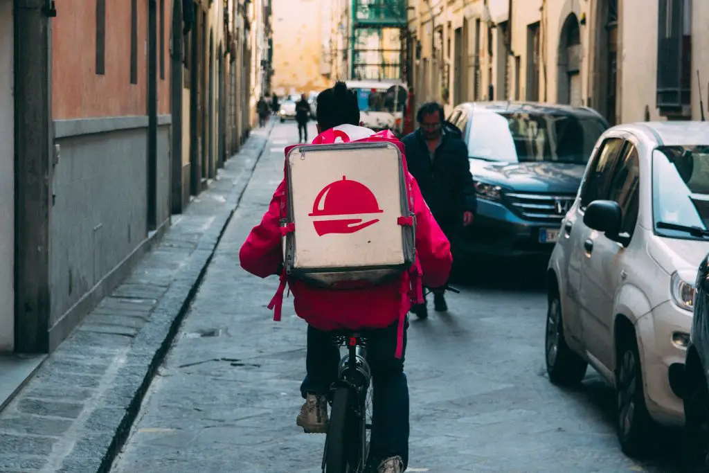 A man on a bicycle with a food delivery. Source: unsplash